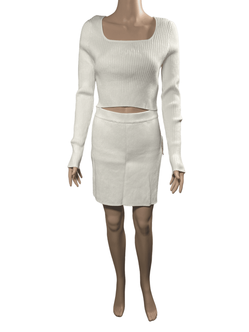 Woman wearing a white knit sweater and matching skirt.