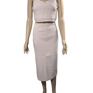 Woman wearing a white sleeveless crop top and matching midi skirt.