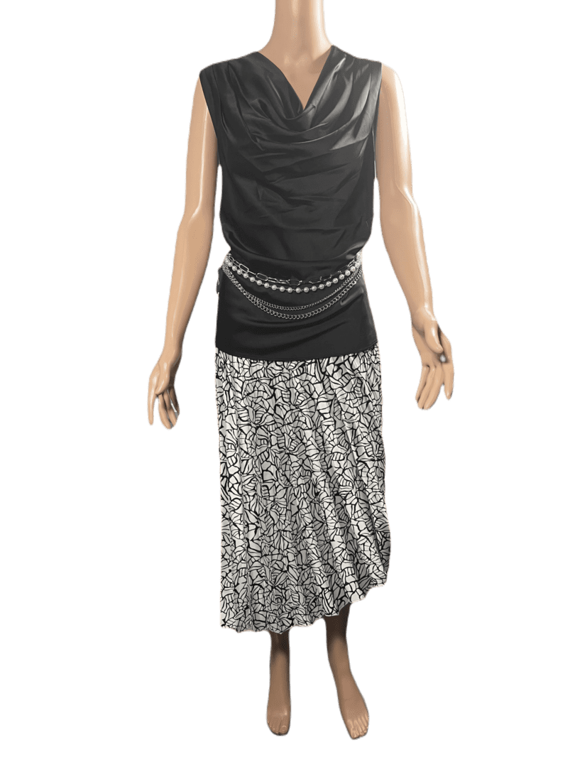 A sleeveless black top paired with a long, pleated silver skirt and a studded belt.