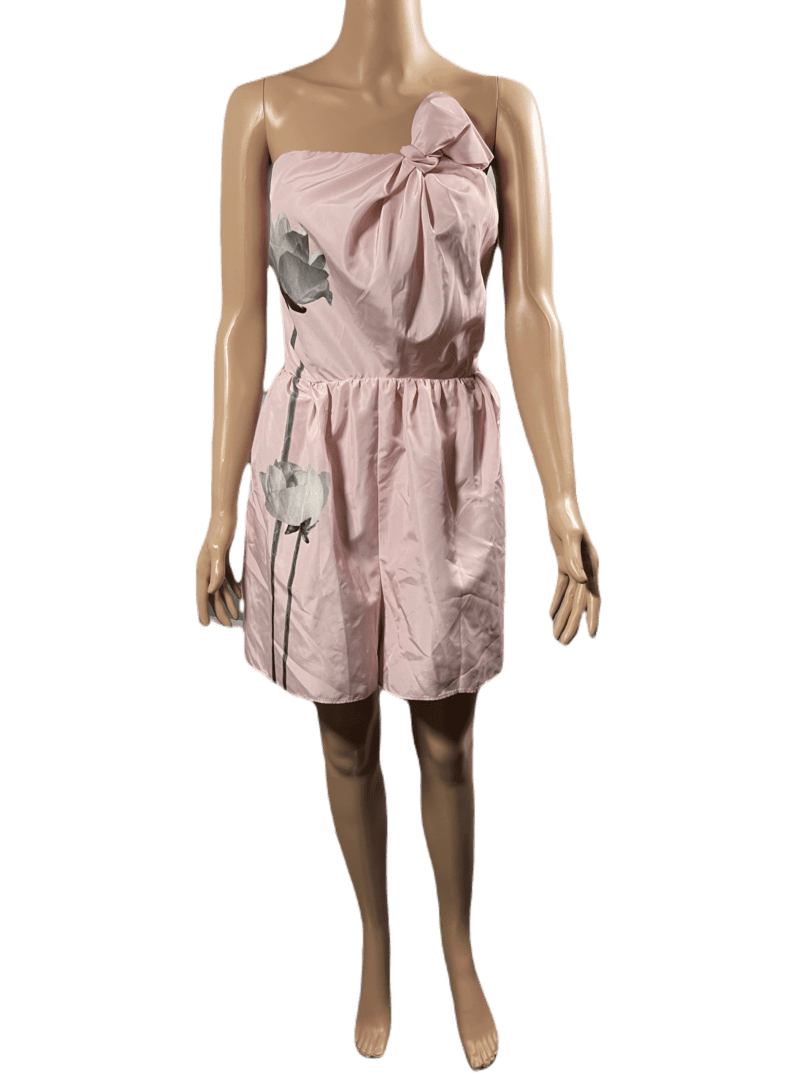 Sleeveless pink dress with a large bow on the chest and a cinched waist.