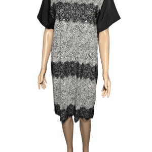 A sleeveless knitted dress with black and gray stripes over a black short-sleeve shirt.