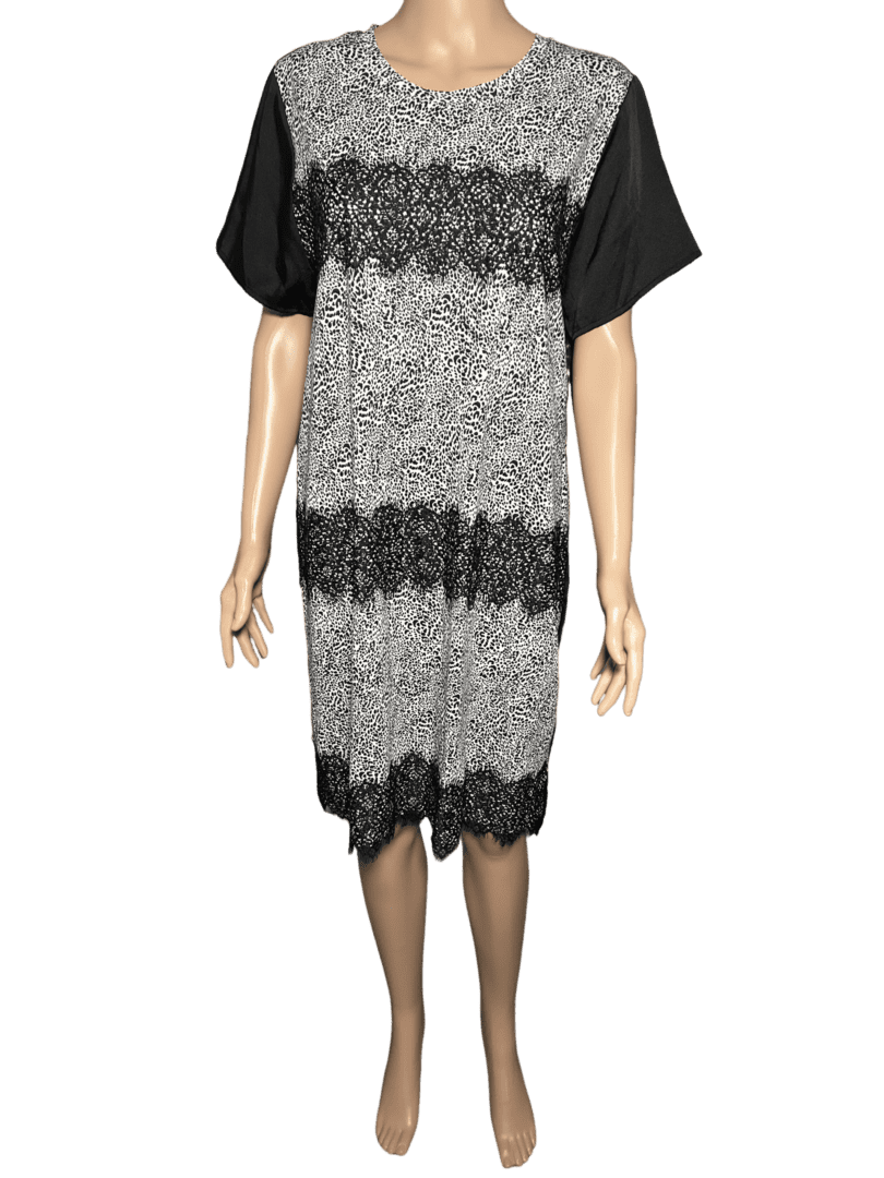 A sleeveless knitted dress with black and gray stripes over a black short-sleeve shirt.