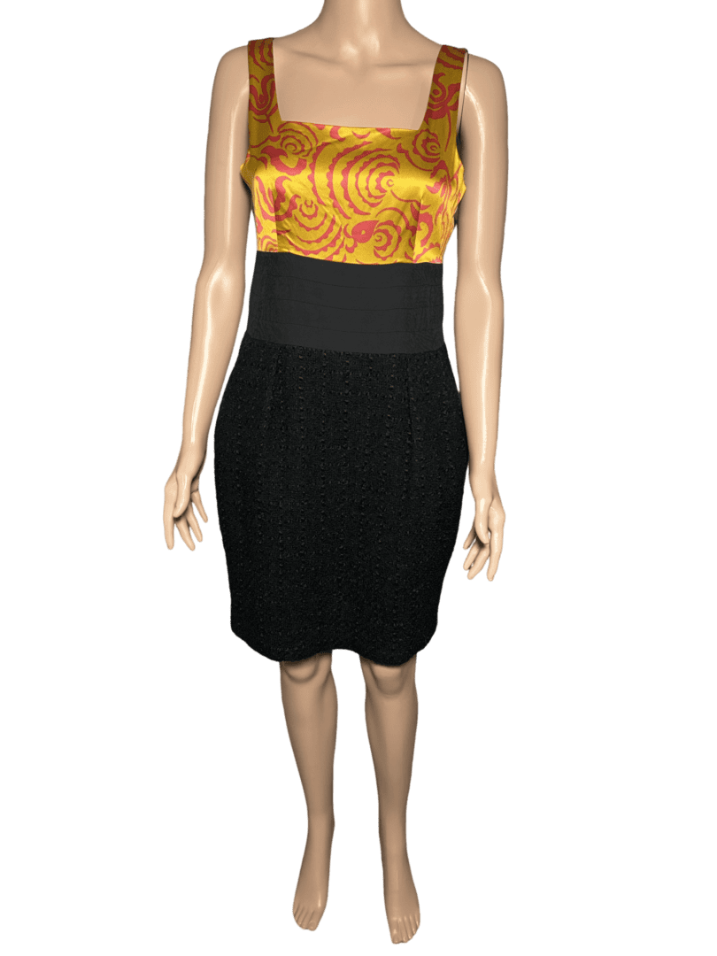 Woman wearing a black skirt and a colorful orange top.