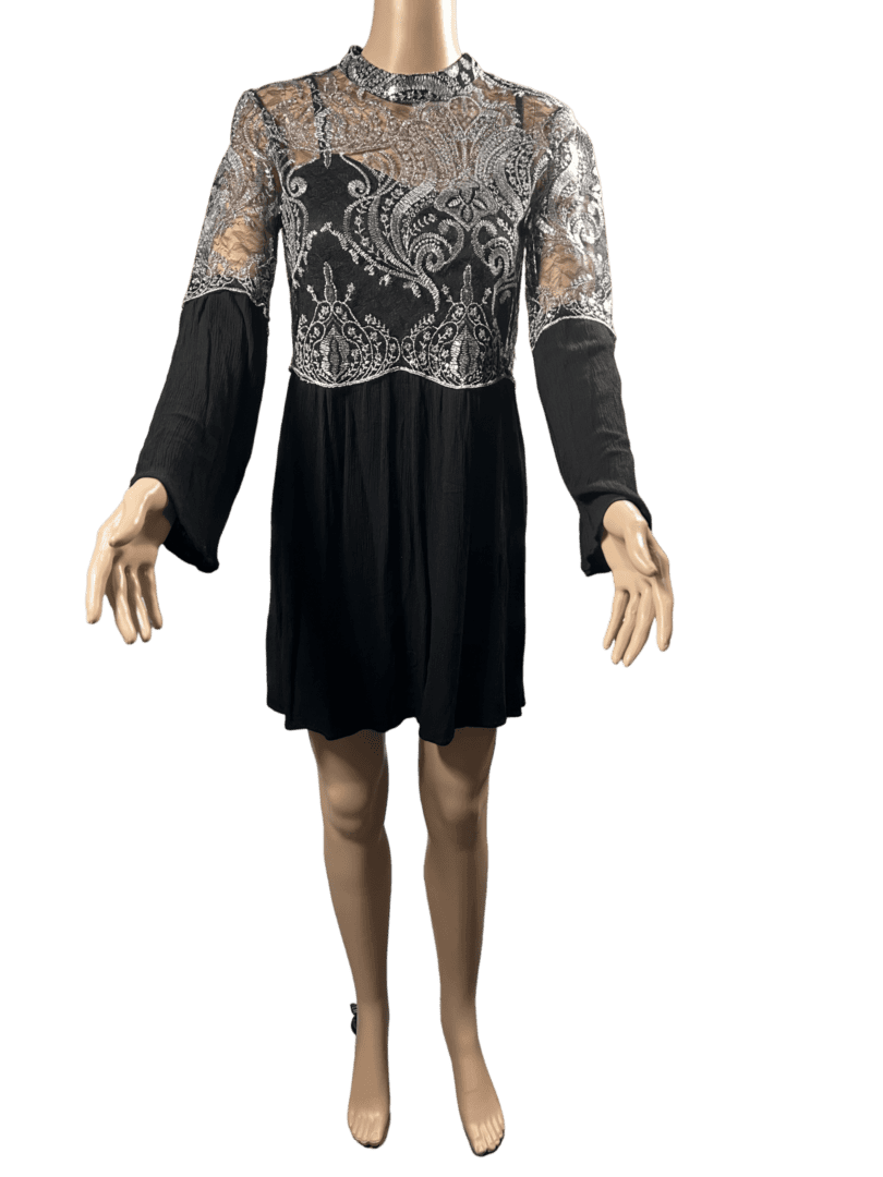 Black dress with lace detailing and long sleeves, worn by a mannequin.