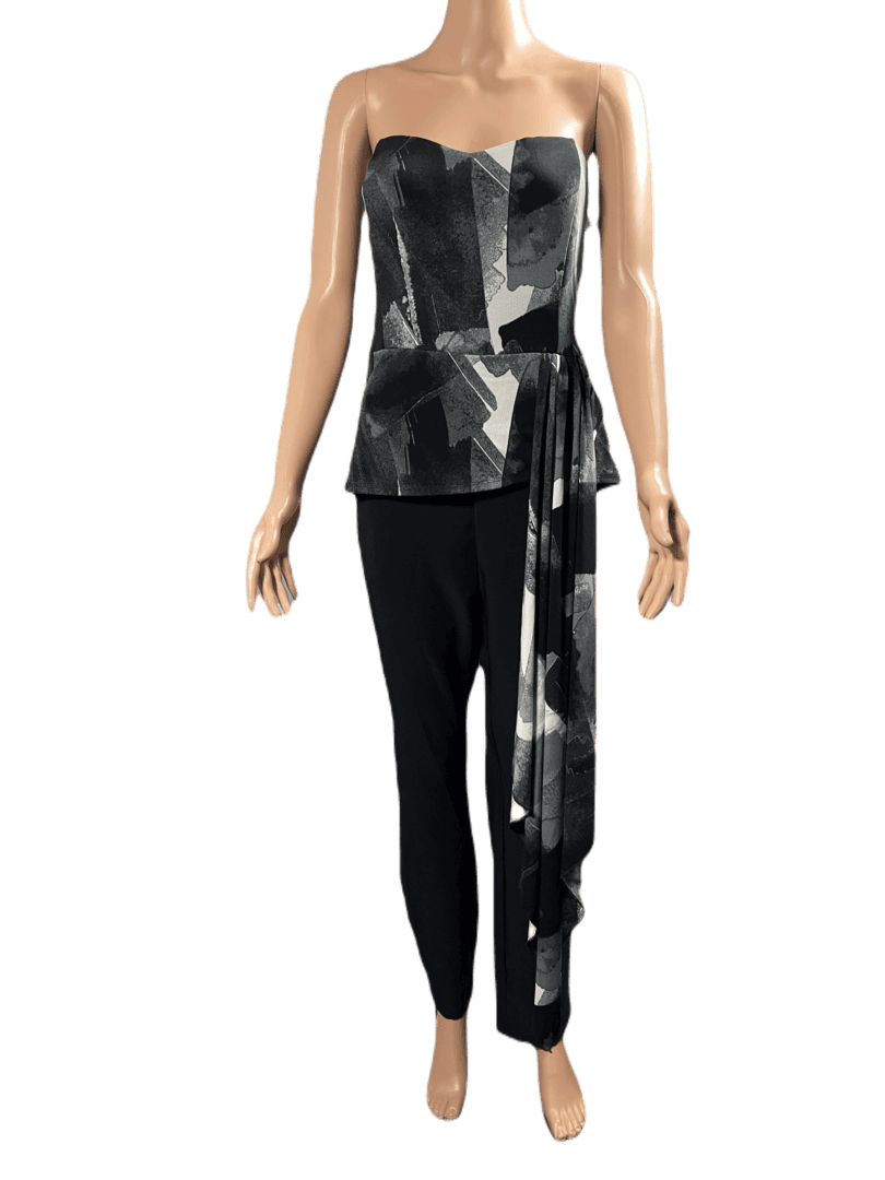 Woman in a stylish black and white abstract top with black pants.