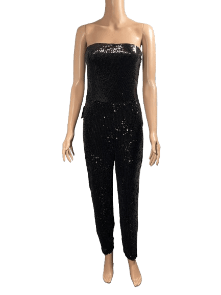 Woman wearing a black strapless jumpsuit with a subtle pattern.