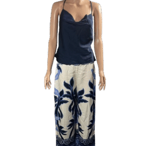 Woman wearing a navy blue camisole and white floral wide-leg pants.