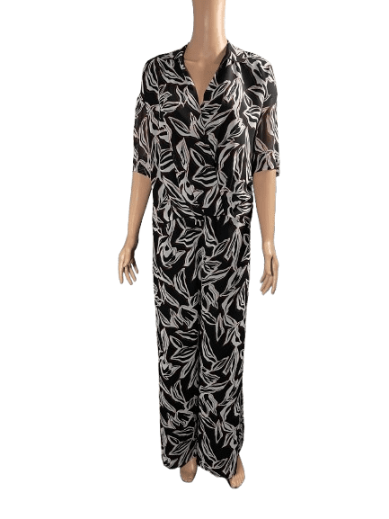 Woman wearing a black and white leaf-patterned jumpsuit.