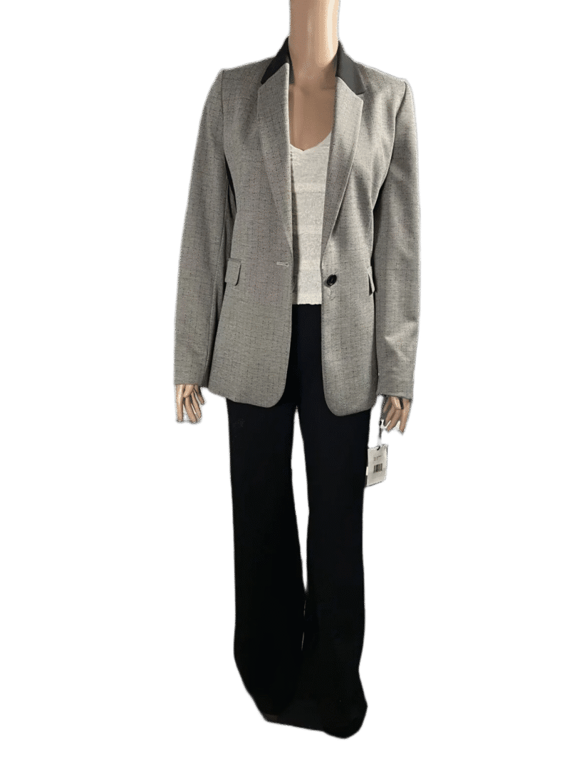 Person wearing a gray blazer, white top, and black pants.