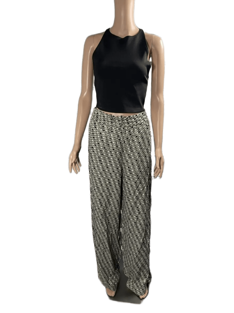 Woman wearing a sleeveless black top and checkered pants.