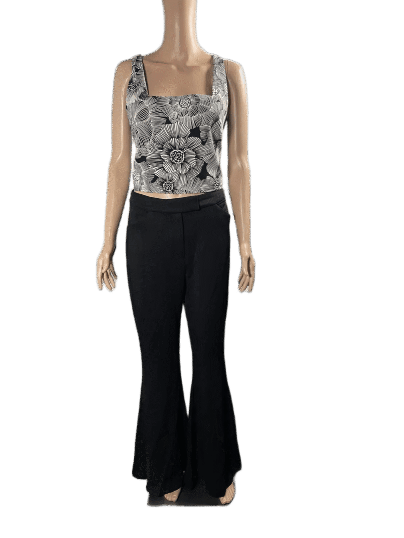 Woman wearing a patterned tank top and black flared pants.