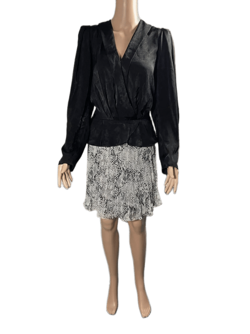 Woman wearing a black blouse and patterned skirt.