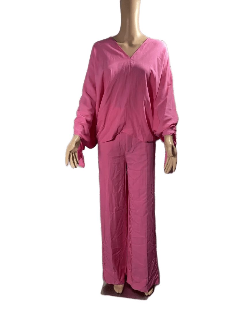 Woman wearing a loose pink outfit with wide pants and a V-neck top.