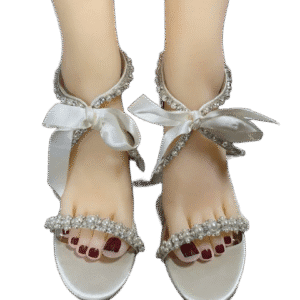 Elegant white sandals with ankle ribbons and red toenail polish.