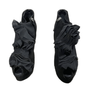 Pair of black open-toe high-heeled sandals with ruffle design.