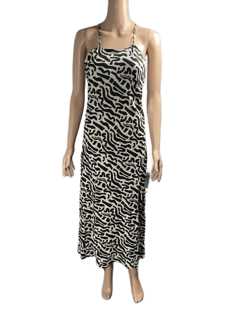Woman wearing a black and white patterned sleeveless maxi dress.
