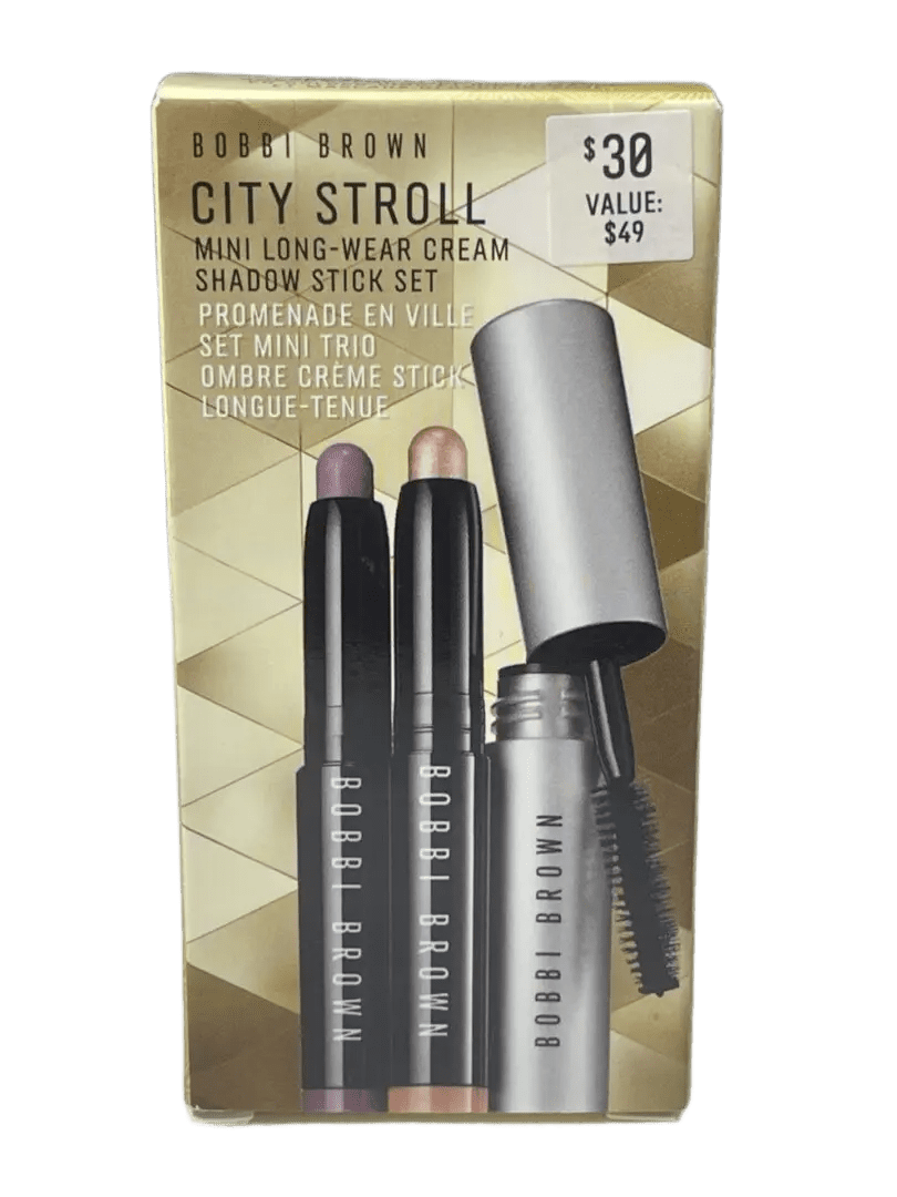 Close-up of three black eyeliner pencils with caps on a gold textured surface.