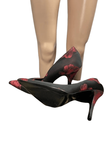 Pair of black high heels with red floral patterns.
