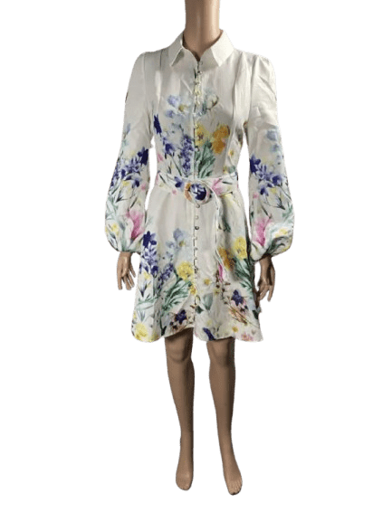 White floral dress with long puff sleeves and ruffled hem.
