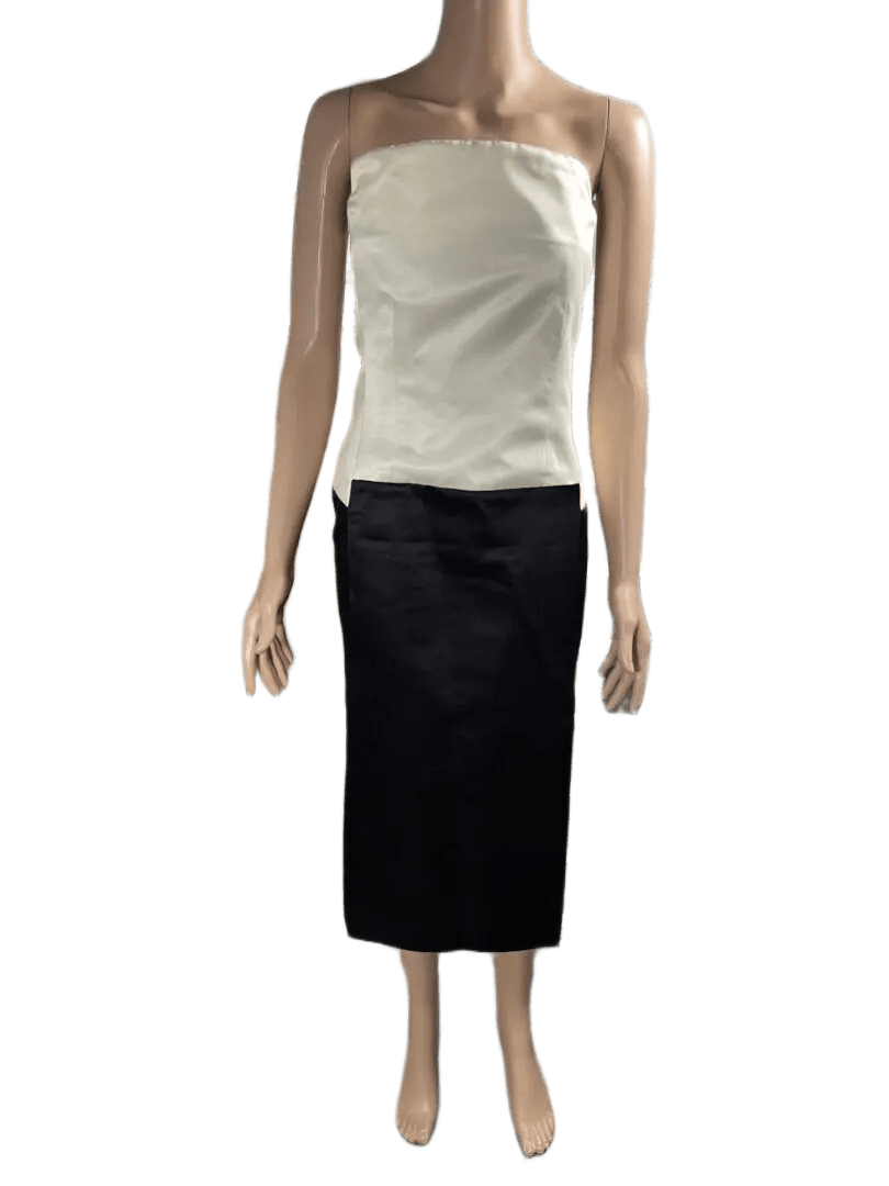 Woman in a white sleeveless top and black skirt.
