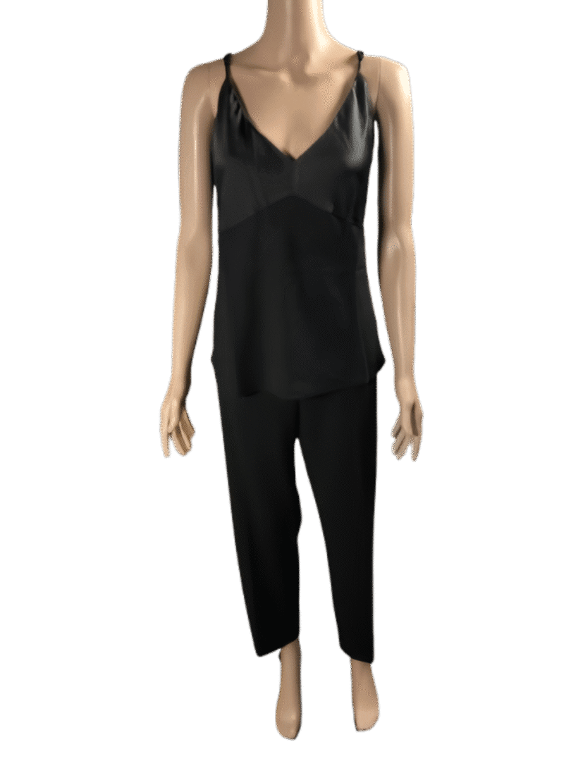 Woman wearing a black sleeveless top and matching black pants.