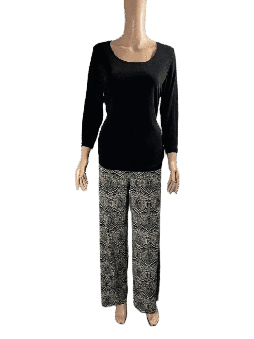 Woman wearing a black long-sleeve top and patterned pants.