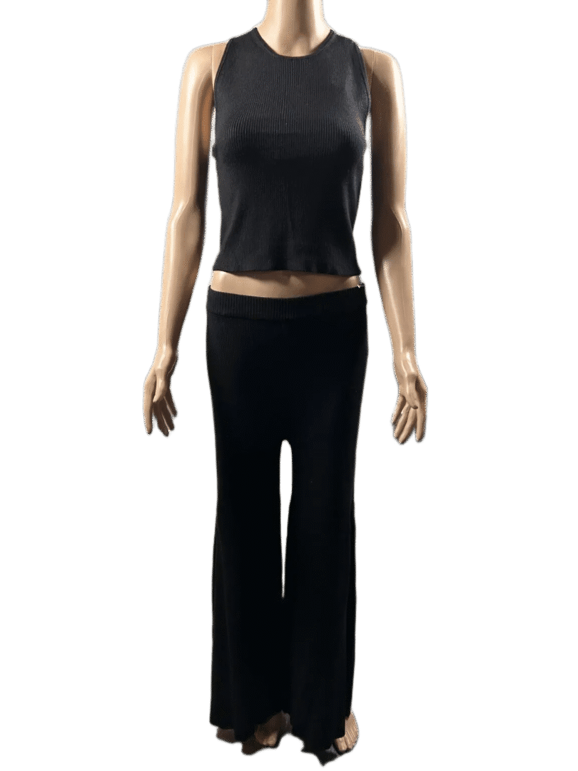 Person wearing a black sleeveless top and black pants, standing with arms relaxed.