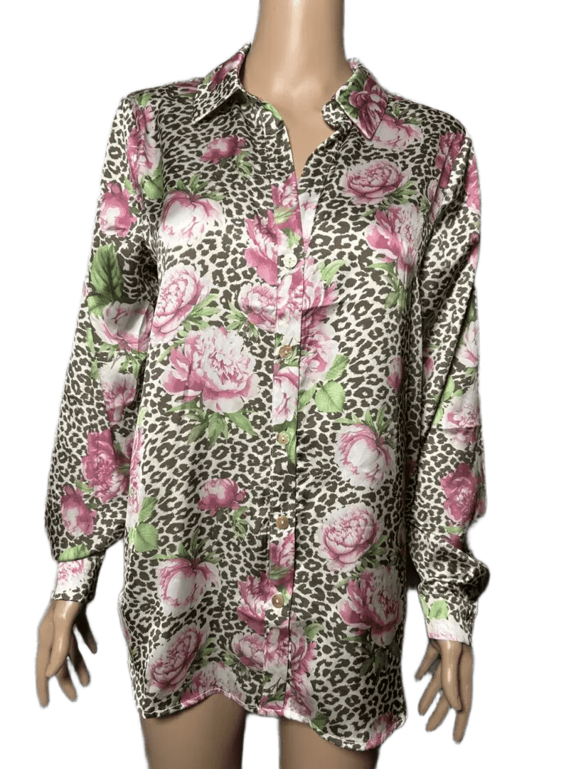 Long floral shirt with pink flowers and green leaves on a beige background.