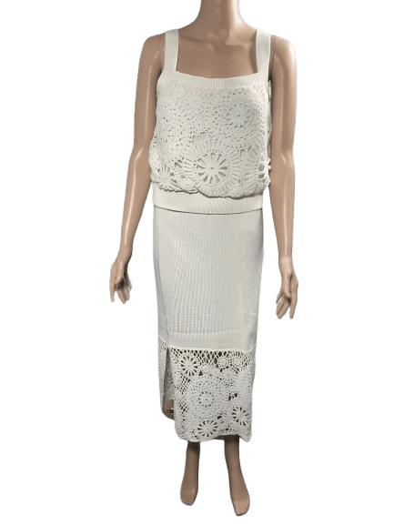 White sleeveless crochet dress with floral patterns and a long skirt.