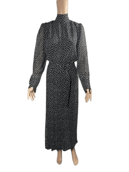 Woman wearing a long black dress with a tie waist.