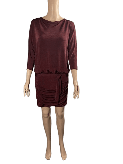 Woman wearing a maroon dress with three-quarter sleeves and a gathered skirt.