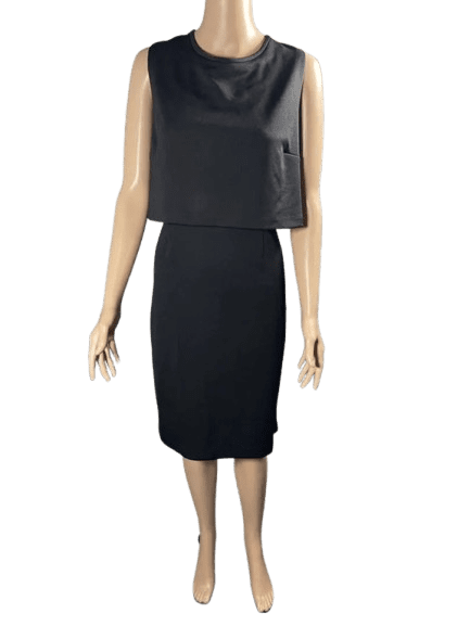 Woman wearing a black sleeveless top and a black pencil skirt.